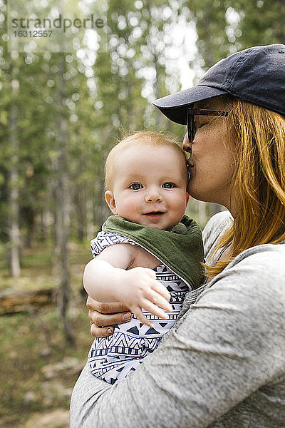 Frau küsst kleinen Sohn (6-11 Monate) im Wald  Wasatch-Cache National Forest