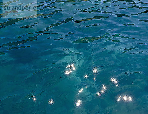Detail des ruhigen Wassers eines Süßwassersees mit Lichtreflexionen