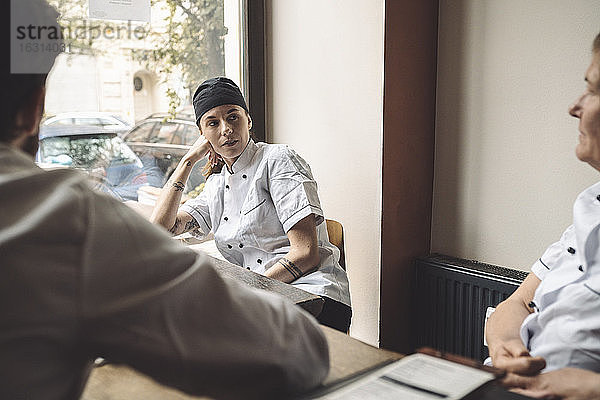 Köchin schaut Mitarbeiterin im Restaurant an