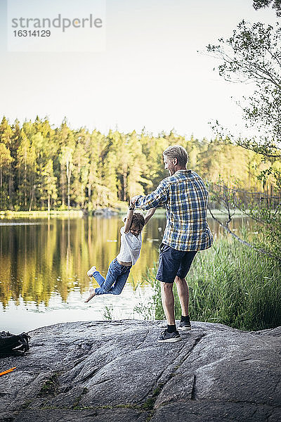 Glücklicher Vater spinnt Tochter am See