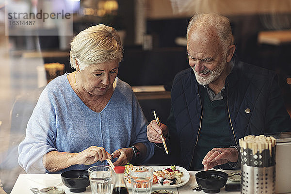 Älteres Ehepaar isst Essen  während es im Restaurant sitzt