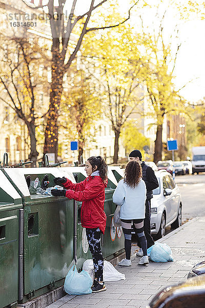 Mann mit Umweltschützerin wirft Plastikflaschen in den Mülleimer