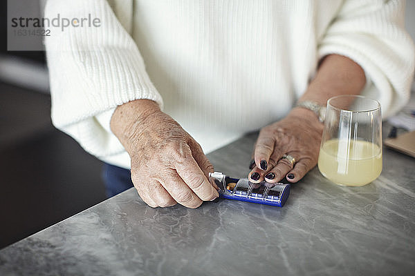 Mittelteil einer älteren Frau  die zu Hause Tabletten nimmt