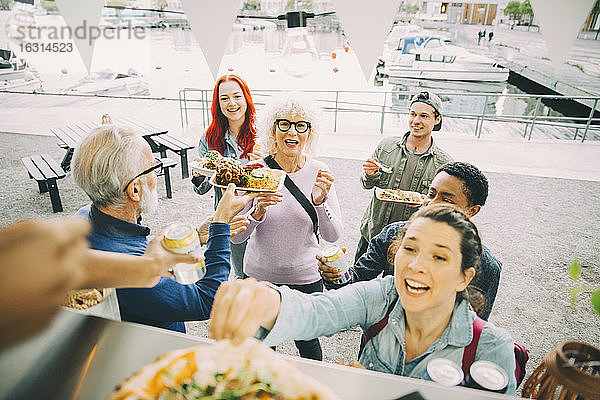 Lächelnde männliche und weibliche Kunden  die sich am Speisewagen in der Stadt vergnügen