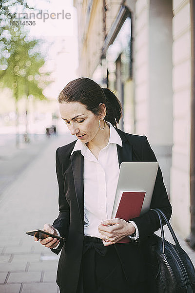 Geschäftsfrau benutzt Smartphone in der Stadt