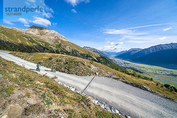 Erhöhter Blick auf Touristen  die mit dem Downhill-Roller auf einem Bergpfad fahren  Celerina  Engadin  Kanton Graubünden  Schweiz  Europa