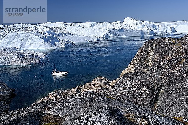 Fischer mit Boot vor gigantischen Eisbergen  UNESCO-Weltnaturerbe  Ilulissat  Diskobucht  Westgrönland  Grönland  Nordamerika