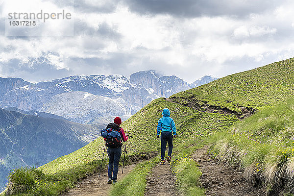 Rückansicht einer Mutter mit männlichem Kind beim Trekking um die Langkofelgruppe  Dolomiten  Trentino-Südtirol  Italien  Europa