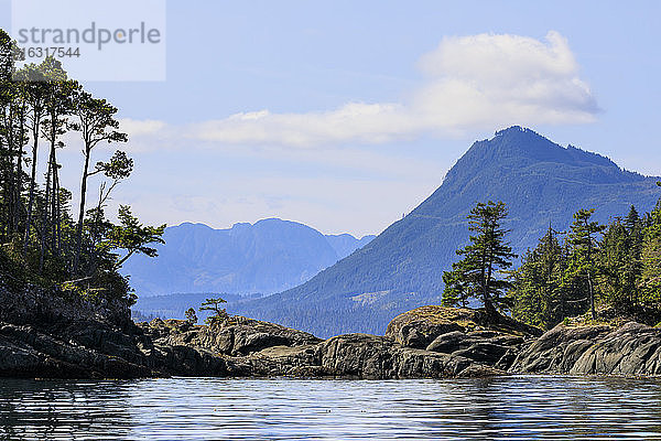 Baumgesäumte Felsküste einer Insel bei ruhiger See in der Nähe der Alert Bay  Inside Passage  Britisch-Kolumbien  Kanada  Nordamerika  Nordamerika