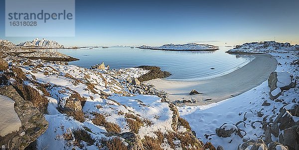 Verschneiter weißer Sandstrand in winterlicher Bucht  blaues Meer  hinten Lofotengipfel  Nordland  Lofoten  Norwegen  Europa