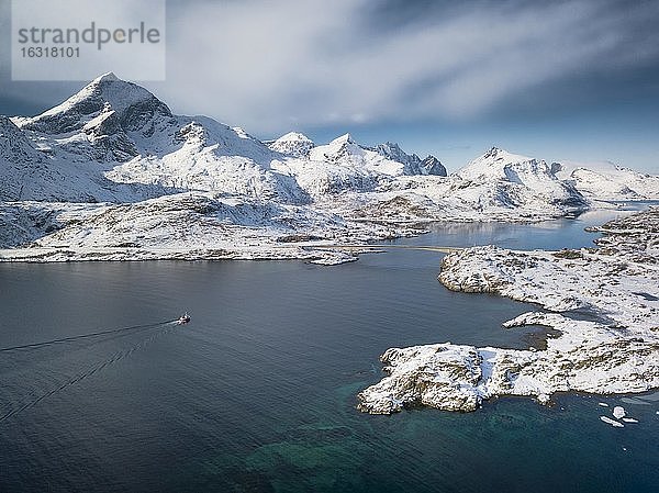 Luftaufnahme  türkiser Fjord mit verschneiten Bergen  Straßenbrücke und kleines Fischerboot  Nordland  Lofoten  Norwegen  Europa