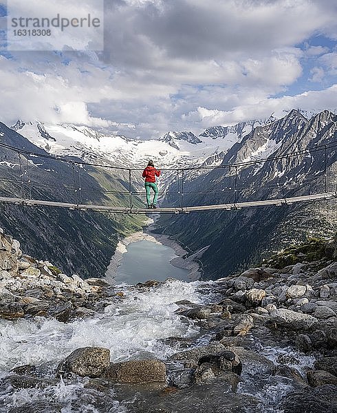 Wanderin  Frau auf Hängebrücke an der Olpererhütte  Schlegeisstausee  Speicher Schlegeis  Zillertaler Alpen  Gletscher Schlegeiskees  Zillertal  Tirol  Österreich  Europa