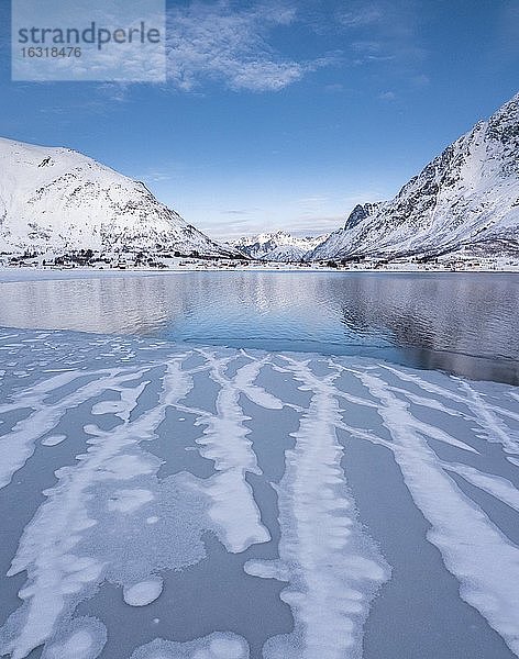 Linien auf Eisfläche an einem Fjord  hinten blaues Meer und Berge  Nordland  Lofoten  Norwegen  Europa