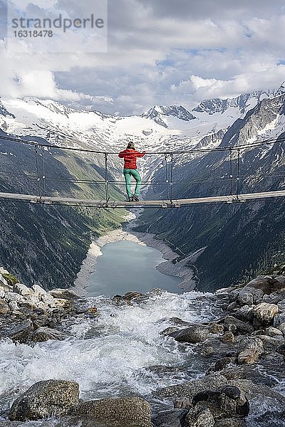 Wanderin  Frau auf Hängebrücke an der Olpererhütte  Schlegeisstausee  Speicher Schlegeis  Zillertaler Alpen  Gletscher Schlegeiskees  Zillertal  Tirol  Österreich  Europa