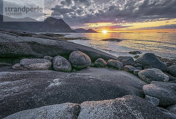 Sonnenuntergang am Meer  vorne felsige Küste  Ramberg  Napp  Lofoten  Nordland  Norwegen  Europa