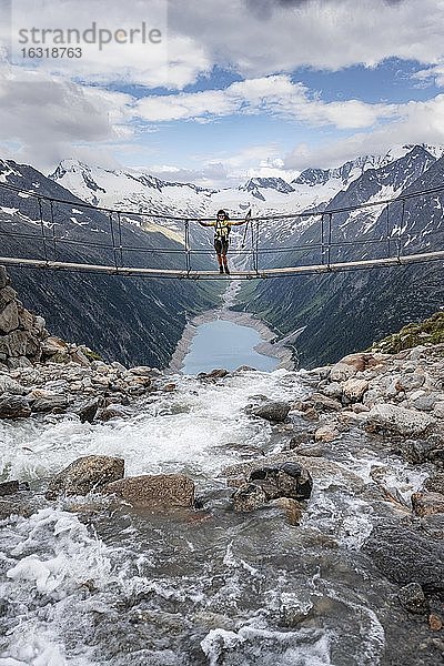 Wanderin  Frau auf Hängebrücke an der Olpererhütte  Schlegeisstausee  Speicher Schlegeis  Zillertaler Alpen  Gletscher Schlegeiskees  Zillertal  Tirol  Österreich  Europa