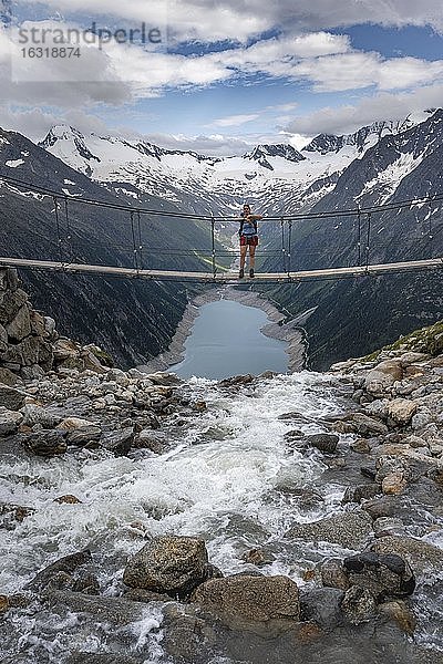 Wanderin  Frau auf Hängebrücke an der Olpererhütte  Schlegeisstausee  Speicher Schlegeis  Zillertaler Alpen  Gletscher Schlegeiskees  Zillertal  Tirol  Österreich  Europa