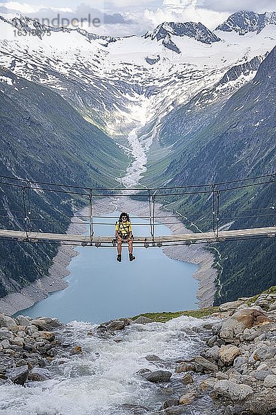 Wanderin  Frau auf Hängebrücke an der Olpererhütte  Schlegeisstausee  Speicher Schlegeis  Zillertaler Alpen  Gletscher Schlegeiskees  Zillertal  Tirol  Österreich  Europa