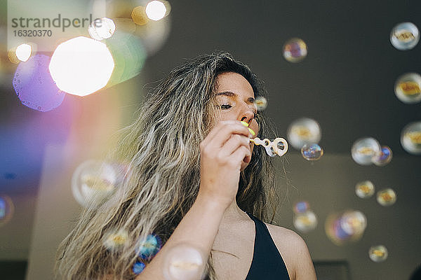 Junge Frau beim Blasen von Seifenblasen