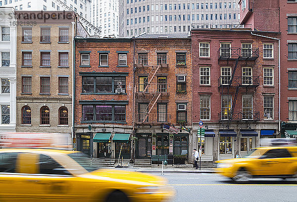 USA  New York City  Manhattan  gelbe Taxis fahren vor alten Backsteinhäusern