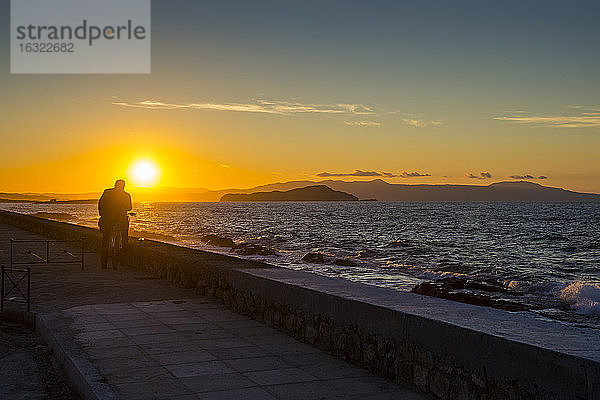 Griechenland  Kreta  Mann genießt den Sonnenuntergang in Chania