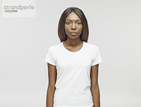 Porträt einer ernst dreinblickenden jungen Frau mit weißem T-Shirt