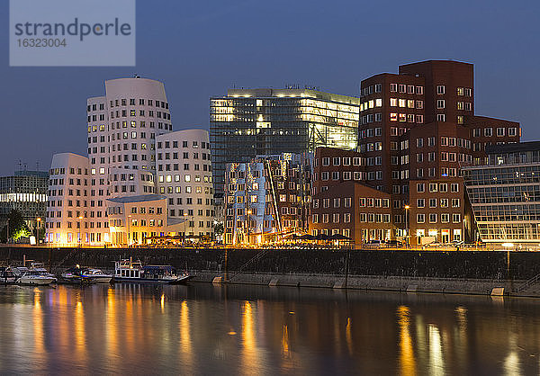 Deutschland  Düsseldorf  beleuchtete Gehry-Gebäude mit Medienhafen am Abend