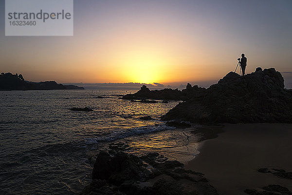Spanien  Katalonien  Lloret de Mar  Platja de Santa Christina  Silhouette eines Fotografen bei Sonnenaufgang