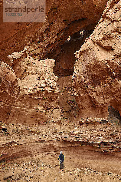 Algerien  Sahara  Tassili N'Ajjer National Park  Tadrart Region  Tisseteka  Mann steht in einem riesigen Schlagloch