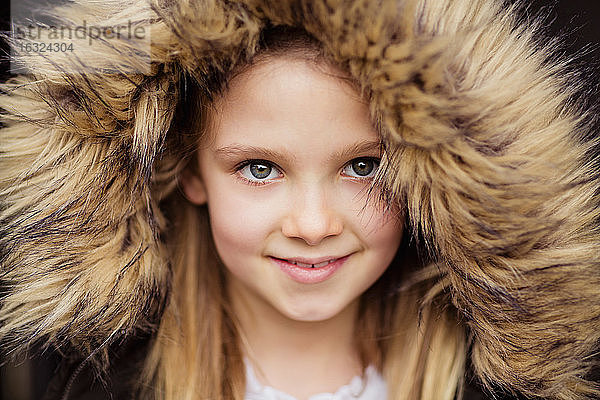 Porträt eines lächelnden Mädchens mit Plüschkapuze