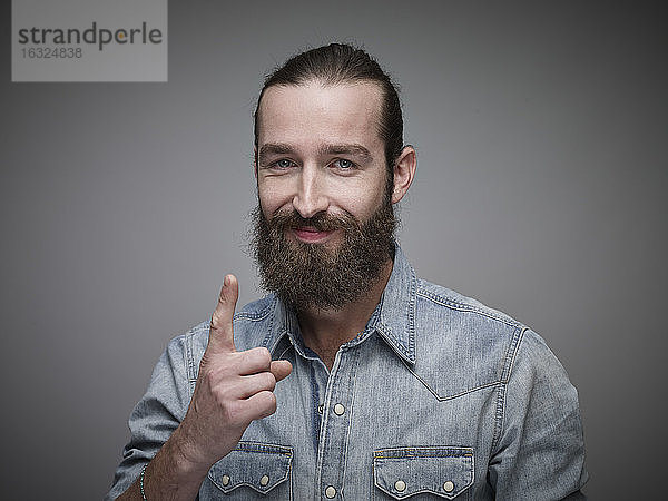 Porträt eines Mannes mit ausgestrecktem Zeigefinger