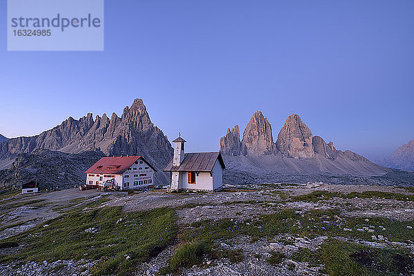 Kapelle und Refugio Antonio Locatelli mit den berühmten Drei Zinnen und dem Berg Paterno bei Sonnenaufgang  Trentino-Südtirol  Italien