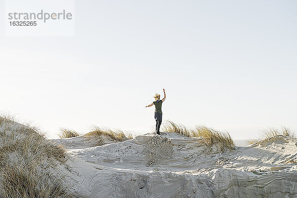 Dänemark  Henne Strand  Glückliche Frau auf Sanddüne stehend