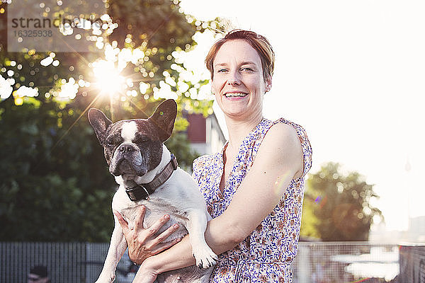 Porträt einer lächelnden Frau mit französischer Bulldogge