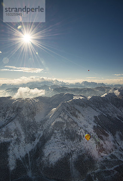 Österreich  Salzkammergut  Heißluftballone über alpiner Landschaft im Winter
