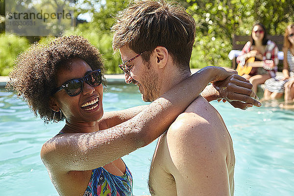 Junges Paar umarmt sich im Schwimmbad