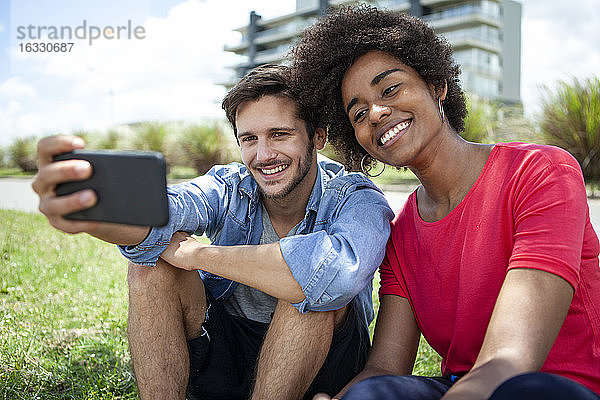 Junges Paar macht Selfie mit Smartphone im Park