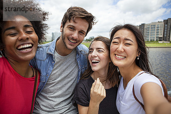Glückliche junge Freunde nehmen Selfie im Freien