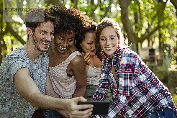 Glückliche junge Freunde nehmen Selfie auf Smartphone im Freien