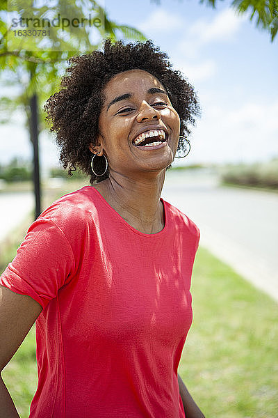 Porträt einer lachenden jungen Frau im Park