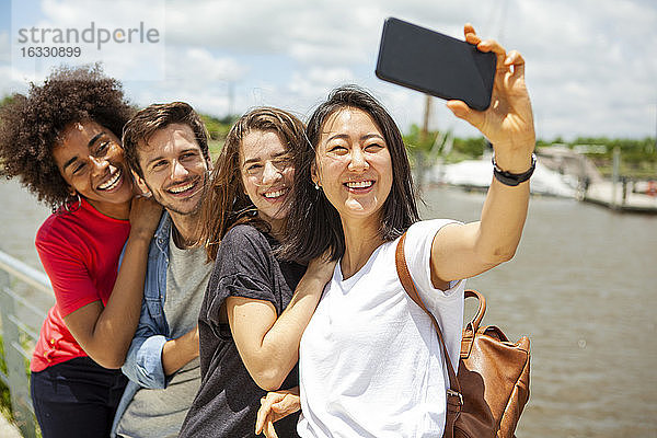Glückliche junge Freunde machen ein Selfie mit ihrem Smartphone