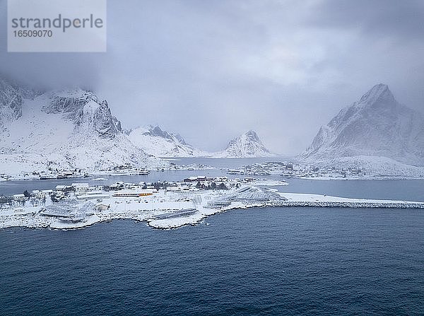 Winterliche Stimmung am Fjord im Fischerdorf  Schneefall in den Bergen  Reine  Nordland  Lofoten  Norwegen  Europa