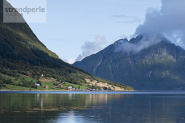 Kleine Siedlung an einem Fjord  hinten Berge mit bewaldeten Hängen  Dalsgrenda  Nordland  Norwegen  Europa