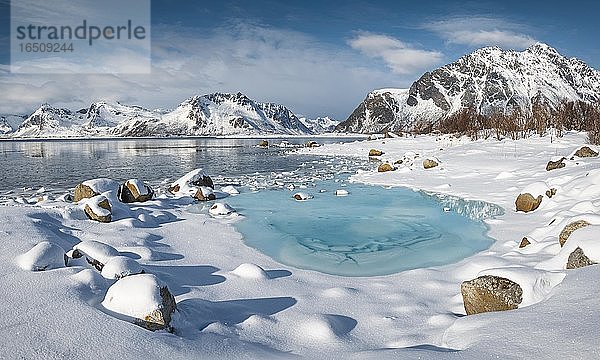 Türkise Lagune mit Schneefläche und Eisschollen  dahinter schneebedeckte Berge  Kleppstad  Nordland  Lofoten  Norwegen  Europa