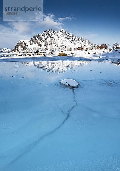 Türkise Lagune mit Eisschollen  dahinter schneebedeckte Berge Sundklakktinden und Varden Anderstinden  Nordland  Lofoten  Norwegen  Europa