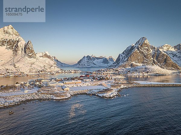 Luftaufnahme  Fjordlandschaft bei Sonnenaufgang  verschneite Berge im Winter  Fischerdorf Reine  Reine  Nordland  Lofoten  Norwegen  Europa