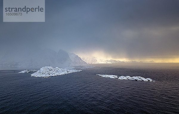 Schneefall über dem Meer und den Bergen  dichte Wolken  Reine  Nordland  Lofoten  Norwegen  Europa