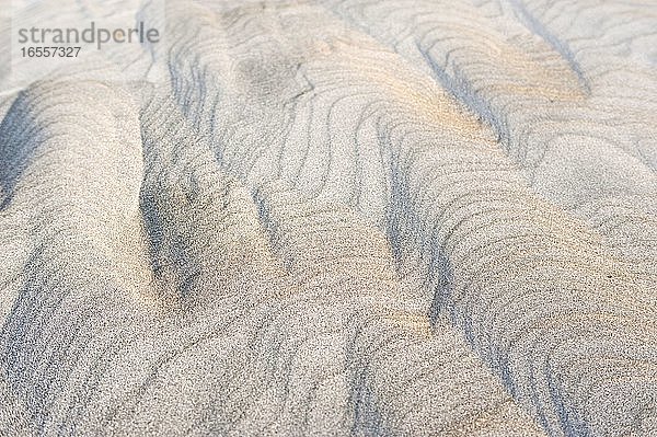 Sandmuster am Wharariki Beach  Golden Bay  Südinsel  Neuseeland. Wharariki Beach ist ein bemerkenswerter  abgelegener  verlassener Sandstrand  der durch starke  treibende Winde verwittert und im Norden der Südinsel Neuseelands in der Golden Bay Area liegt. Die starken Winde führen zu interessanten Formen und Mustern im Sand.
