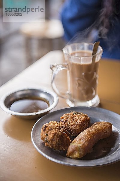 Frittierte Auberginen und birmanischer süßer Tee  ein typisch birmanisches Frühstück auf dem Markt von Kalaw  Shan-Staat  Myanmar (Birma)