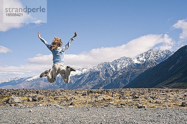 Junge Frau  die vor Freude springt  im Aoraki Mount Cook National Park  Südinsel  Neuseeland